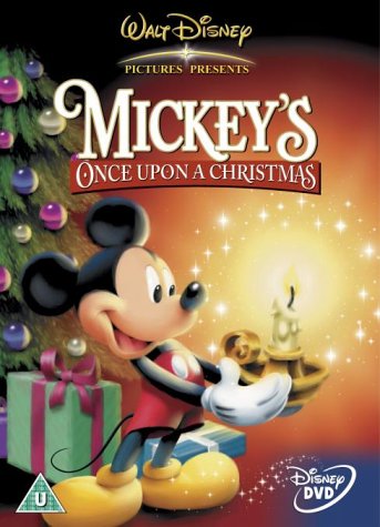 "Mickey Mouse holds a lit candle, beside a Christmas tree and presents."