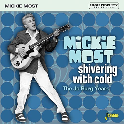 Mickie Most playing an electric guitar against a blue background with large circular patterns.