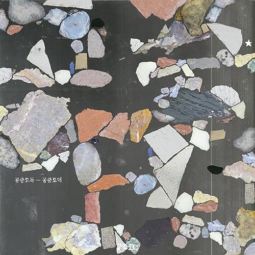Vinyl record cover with abstract arrangement of stone and ceramic fragments.