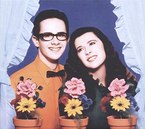 CD cover featuring a smiling couple framed by a torn blue background.