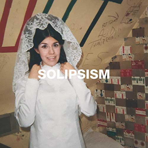 Woman in white dress and veil, with "SOLIPSISM" text, in a room with cassette tapes.