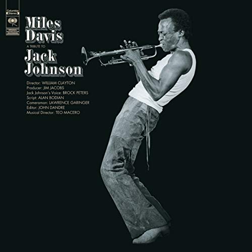 Black and white album cover featuring Miles Davis playing a trumpet against black background.