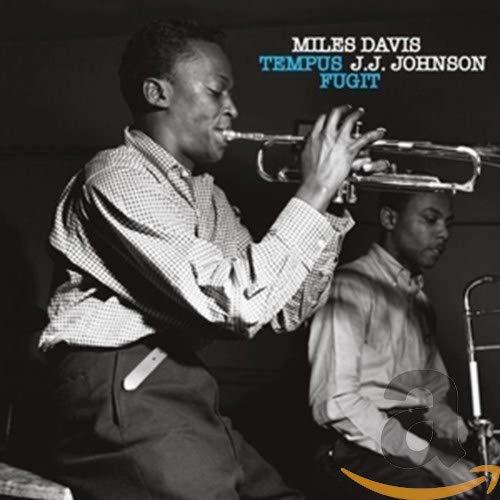 Black and white photo of Miles Davis playing trumpet, J.J. Johnson visible.