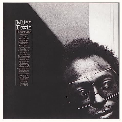 Black and white close-up portrait of Miles Davis wearing glasses on album cover art.
