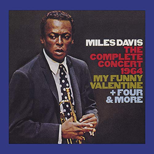 Miles Davis in a suit and polka-dot tie holding a trumpet on album cover.