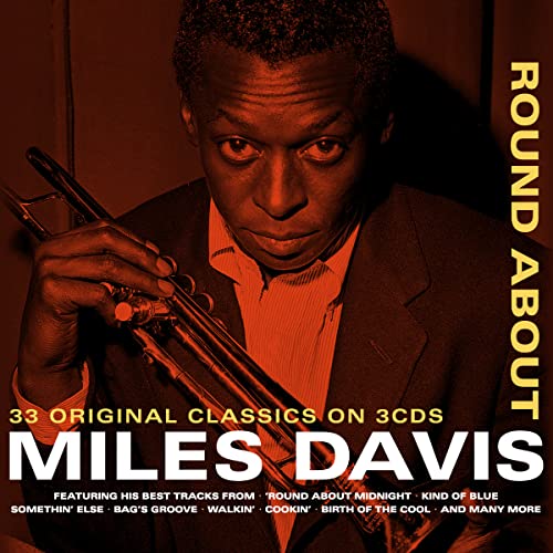 Miles Davis holding a trumpet, album cover in warm red tones.