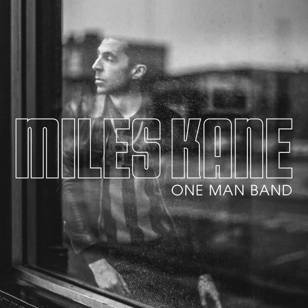 "Album cover for 'One Man Band' by Miles Kane, featuring a man behind a window."