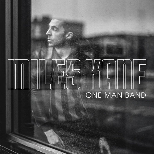 "Album cover for 'One Man Band' by Miles Kane, featuring a man behind a window."
