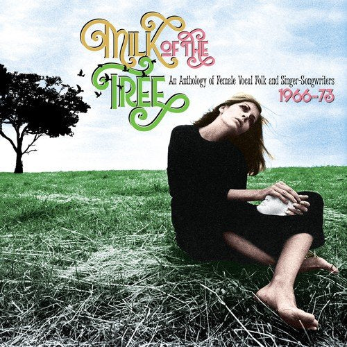 A woman sits in a field with the album cover "Milk of the Tree" above her.
