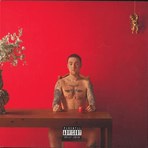 Album cover: Man with tattoos seated at a table with an apple.