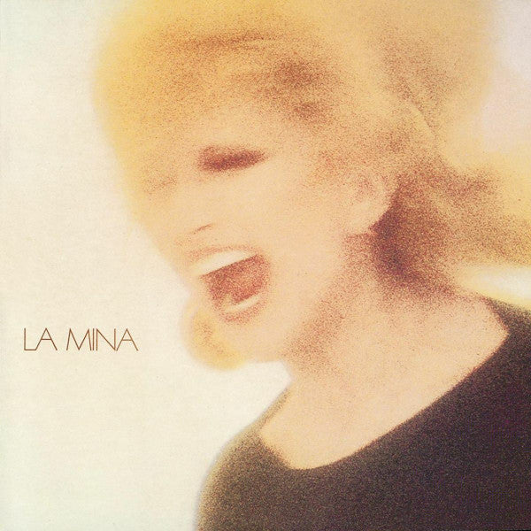 Close-up of Mina, a woman with blonde hair, singing into the void.