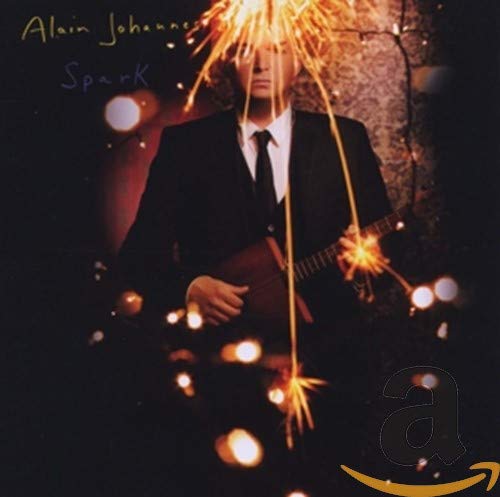 CD cover: man in suit with sparklers, dark background, blurred lights.