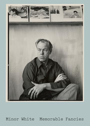 Black and white portrait of a man with photographs in the background.