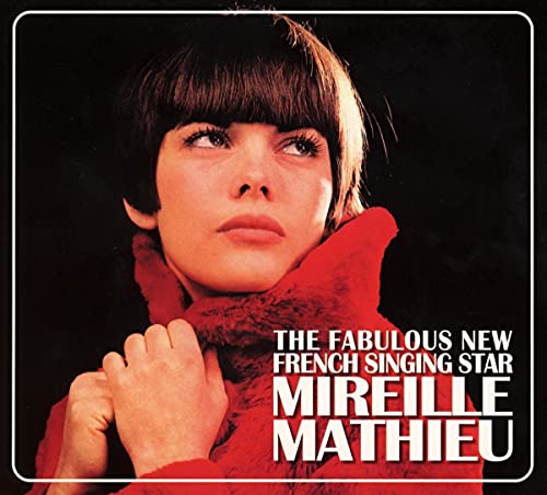 A portrait of Mireille Mathieu wearing a red coat against a black background.