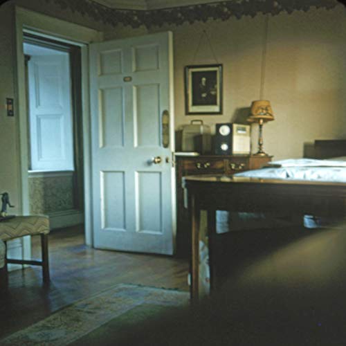 A dimly lit room with a table, radio, and open door to a hallway.
