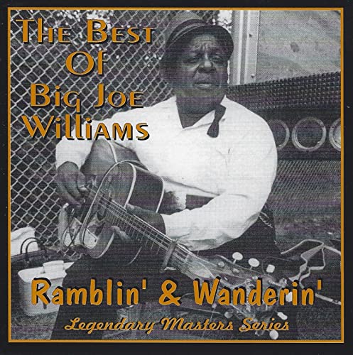 Black and white photo of a man playing an acoustic guitar.