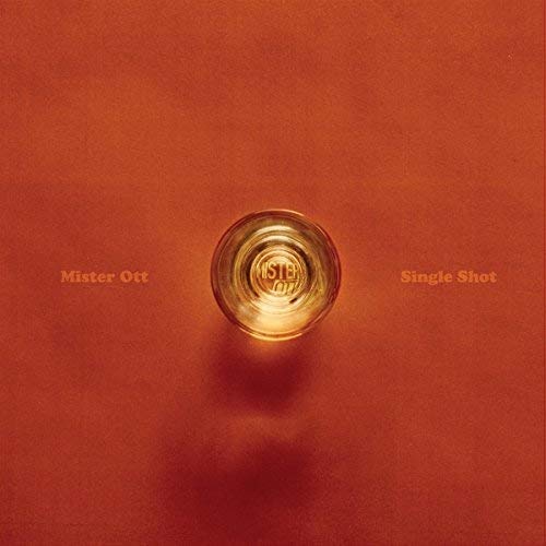 A shot glass centered on a textured orange background with text reading Mister Ott Single Shot.