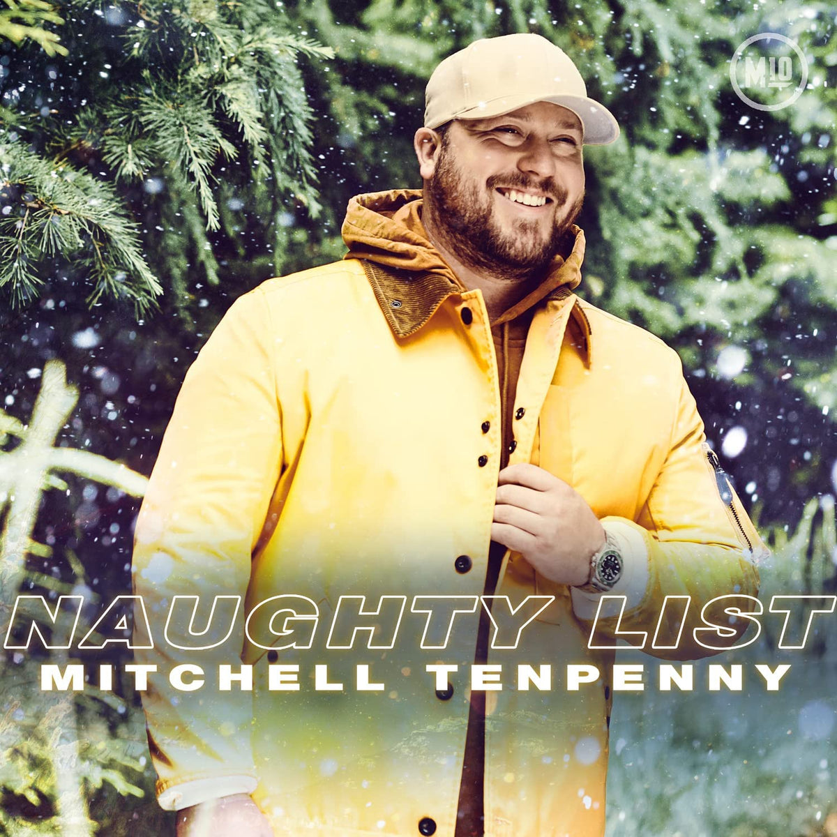 Mitchell Tenpenny smiles, wearing a yellow jacket, with "Naughty List" text.