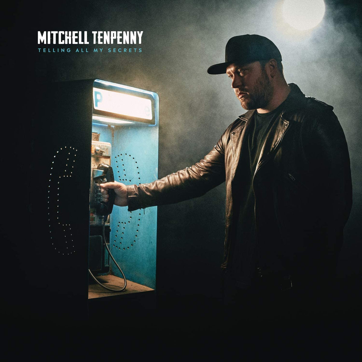 "Album cover featuring a man in a leather jacket using a payphone."