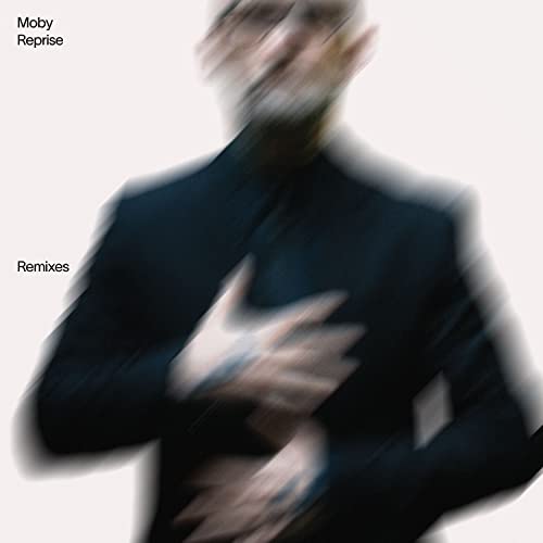 Blurred image of a man in a black shirt against a white background.