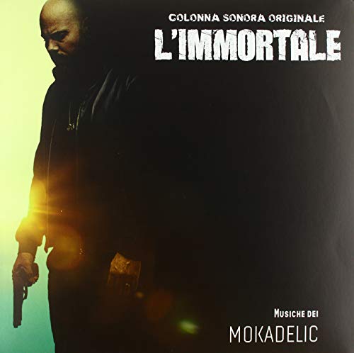 Vinyl record cover featuring a bald man holding a gun, dark background.