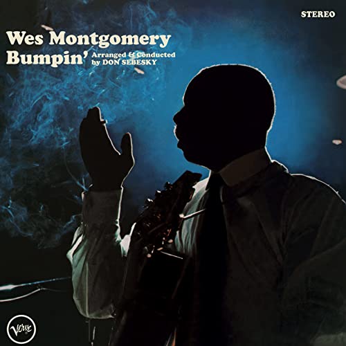 Silhouette of Wes Montgomery holding a guitar against a blue smoky background.