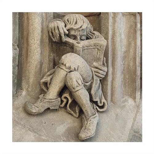 Stone carving of a seated figure reading a large book.