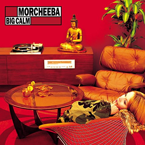 Album cover: woman relaxing on orange couch with Buddha statue and record player nearby.