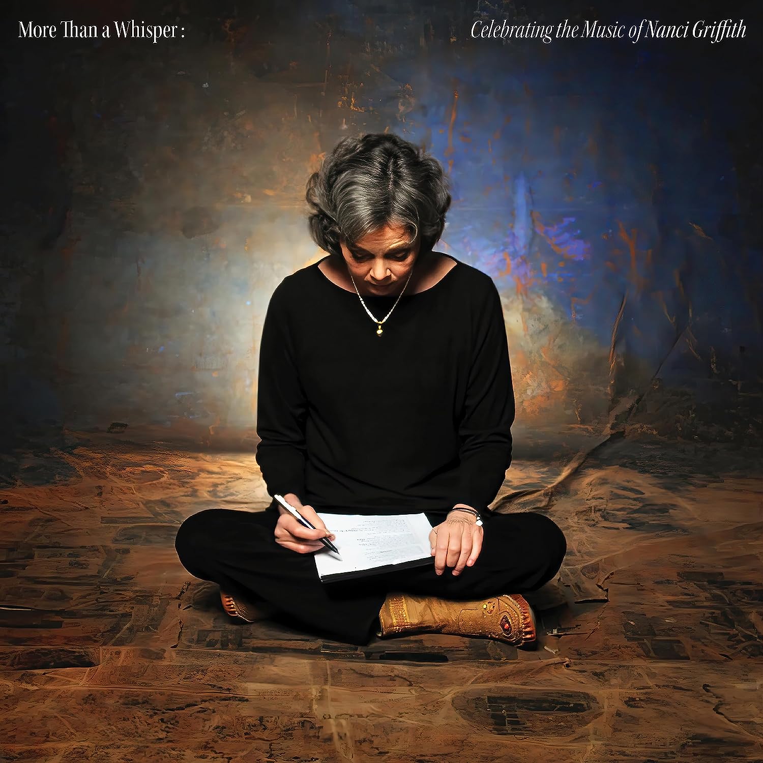 Nanci Griffith portrait, seated and writing on a textured background.