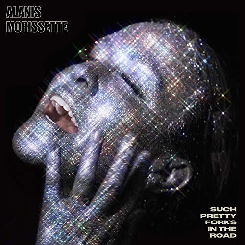 Alanis Morissette's face and hands covered in sparkling glitter against a black background.