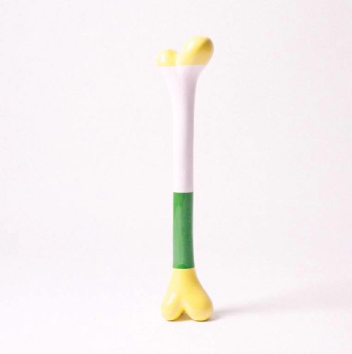 Yellow and white ceramic sculpture resembling a stylized bone.