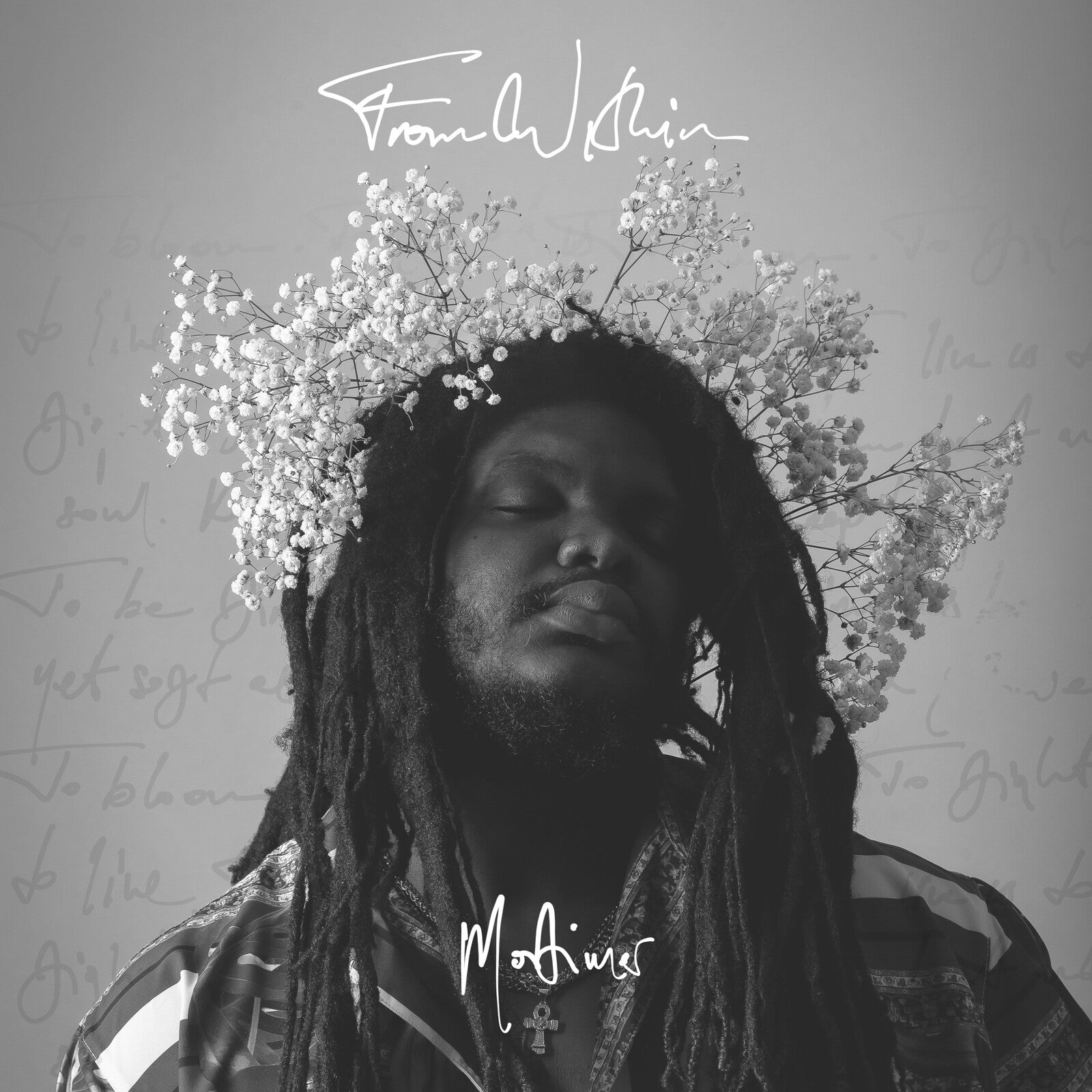 Black and white portrait of a man with dreadlocks and a flower crown.