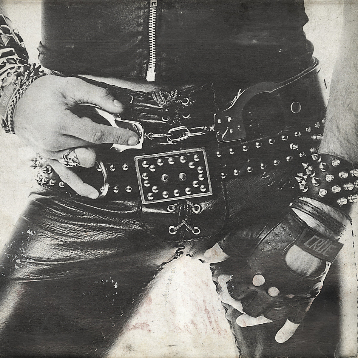 Black and white album cover featuring leather, chains, and a hand with a cigarette.