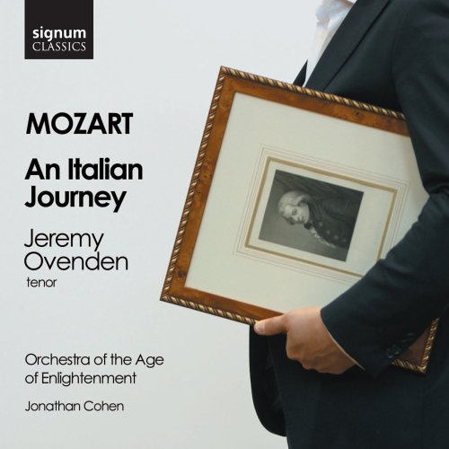A person in a suit holds a framed portrait of Mozart against a white background.