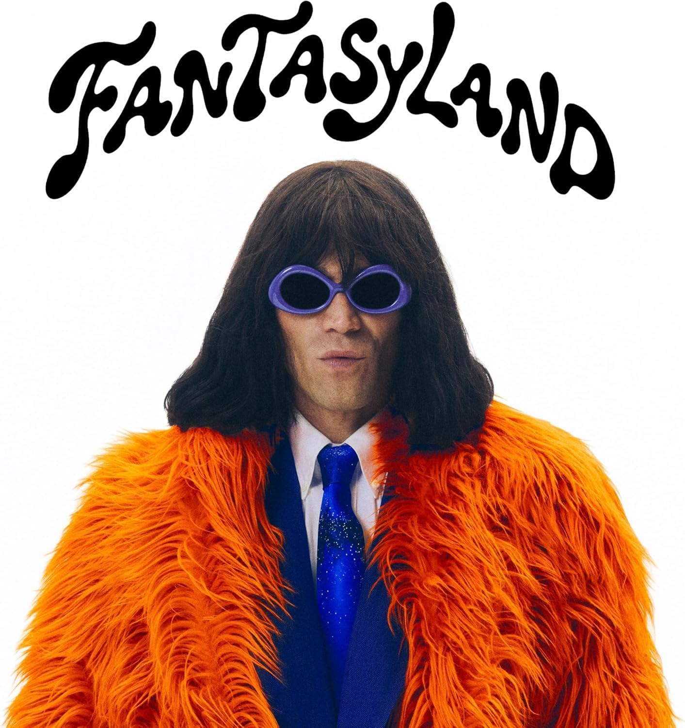 A person with a dark bob wig and purple sunglasses wears an orange fur coat.