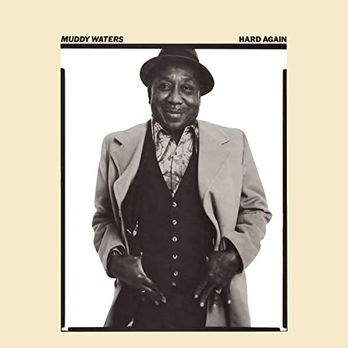 Black and white portrait of Muddy Waters wearing a hat and suit jacket.