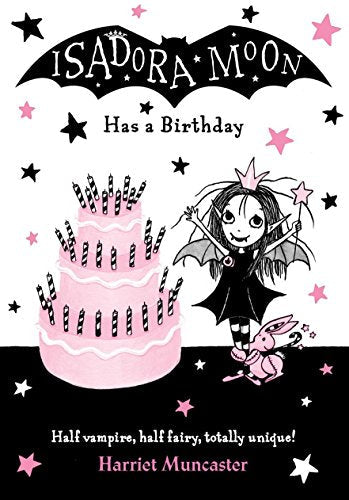 Isadora Moon stands next to a large pink birthday cake with black striped candles.