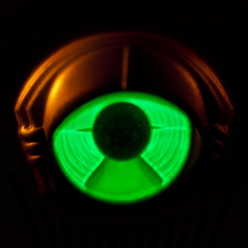 CD case with a glowing green circular design against a dark background.