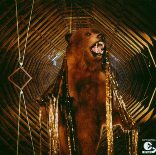 CD cover: taxidermied bear in a wooden, geometrically patterned room.