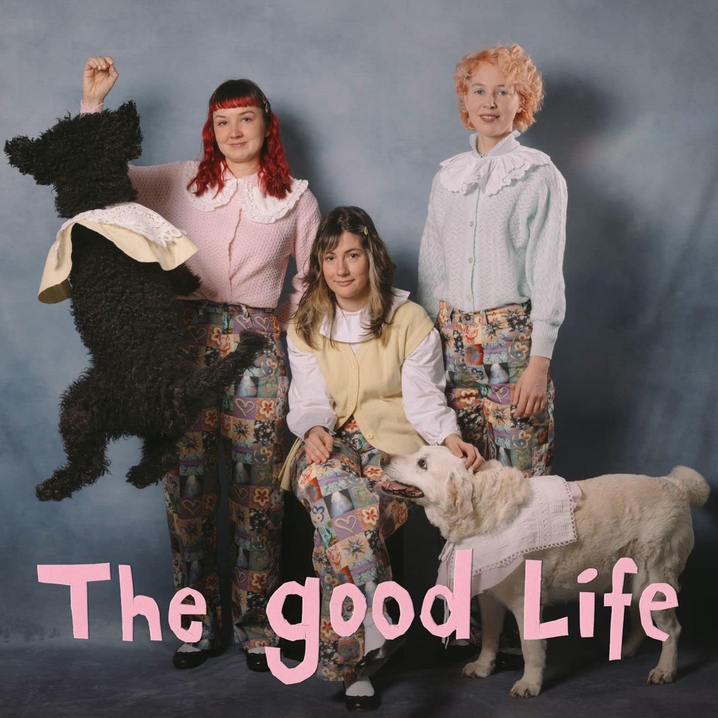 Three women with a poodle and sheep, vintage-style portrait.