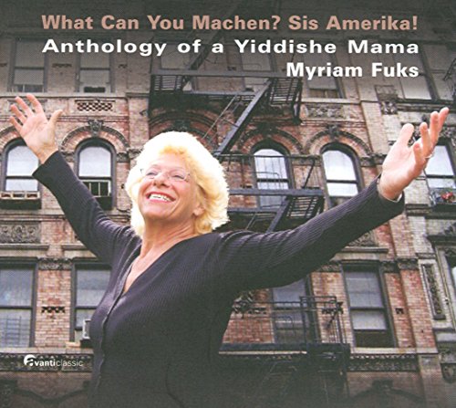 CD cover featuring a smiling blonde woman in black, arms raised, before a brick building.