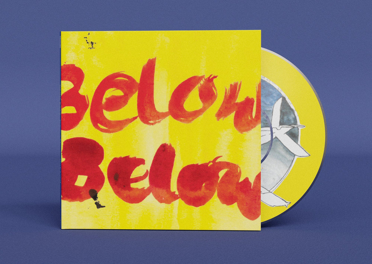 Yellow CD case with red handwritten text and partial disc view.