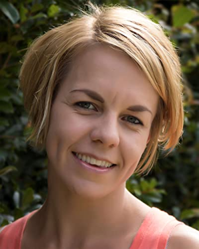 Close-up portrait of a smiling woman with short blonde hair.