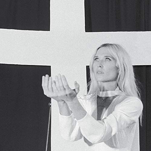 Black and white portrait of Natalie Bergman with hands raised, looking up.