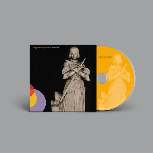"CD case with yellow disc, featuring a medieval knight illustration on black background."