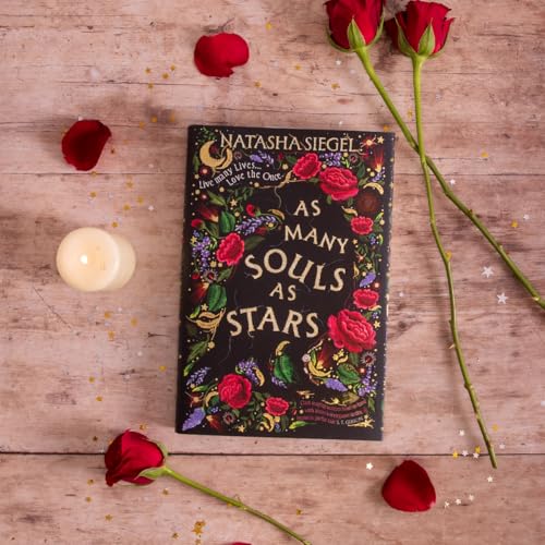 Book cover with floral design, surrounded by roses and a candle.