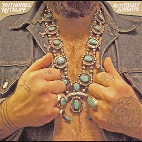 Man wearing a denim jacket and a large turquoise squash blossom necklace.