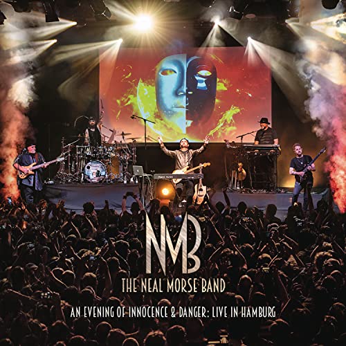 Live concert stage with band performing before a large, blurred audience.
