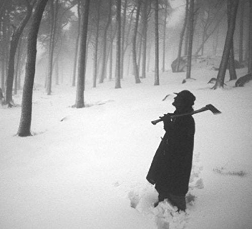 "Album cover: a person in a long coat stands in a snowy forest."