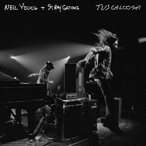 Black-and-white vinyl album cover featuring Neil Young performing live on stage with band.